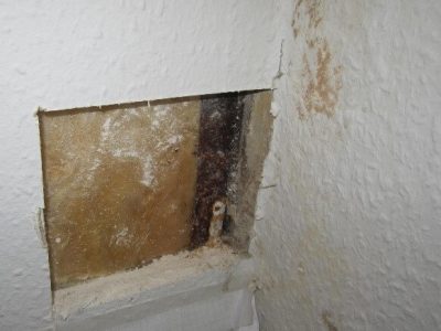 Der er lavet et hul i en væg, som bruges til en destruktiv tilstandsundersøgelse for skimmel. Det kan være nødvendigt at lave hul i en bygningsdel, da skimmel ikke altid er synlig.
